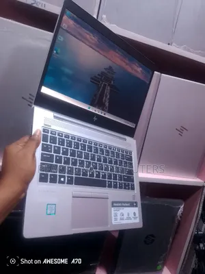 Technician holding an HP EliteBook inside the Peacelink Computers store